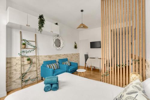 un salon avec un canapé bleu et une table dans l'établissement Le Bohème Chic - Studio Cosy - Métro & Gare, à Toulouse