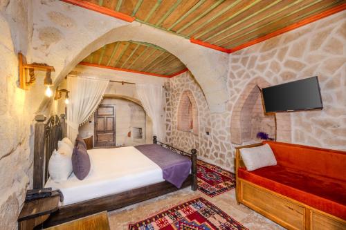 a bedroom with a bed and a tv and a couch at Angel View Suites in Goreme