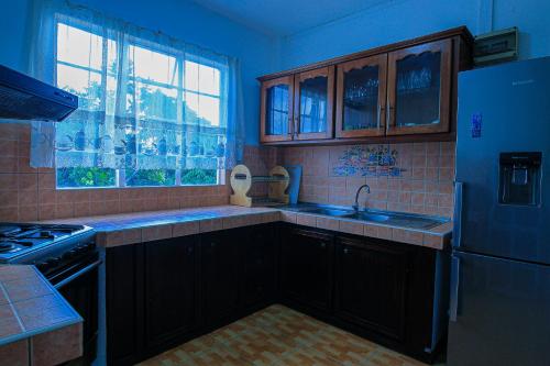 a kitchen with a sink and a refrigerator at St Michel complex in Grand Gaube