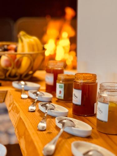 a wooden table with spoons and jars of honey at Auberge Alpina in Gréolières
