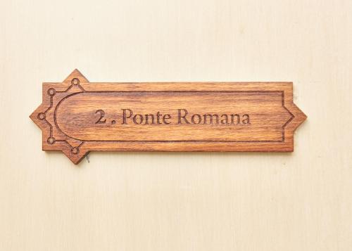 a wooden sign that reads tomato roma on a wall at Taah Billa Guest House in Tavira