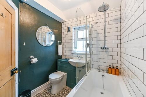 a bathroom with a tub and a toilet and a sink at Beautiful Townhouse, great location - Pet Friendly in Cardiff