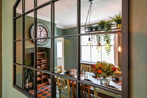 a dining room with a table and a clock at Beautiful Townhouse, great location - Pet Friendly in Cardiff