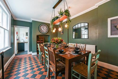 a dining room with a table and chairs and a clock at Beautiful Townhouse, great location - Pet Friendly in Cardiff