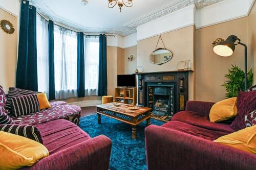 a living room with two couches and a fireplace at Beautiful Townhouse, great location - Pet Friendly in Cardiff