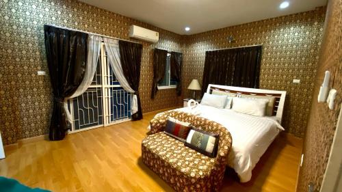 a bedroom with a bed and a chair and a window at Near airport cozy home in Chiang Mai