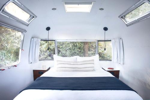a bedroom with a white bed and two windows at AutoCamp Sequoia in Three Rivers