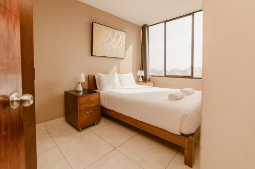 Un dormitorio con una cama grande y una ventana. en GRM1601 Modern 1 BDR with skyline views from Miraflores, en Lima