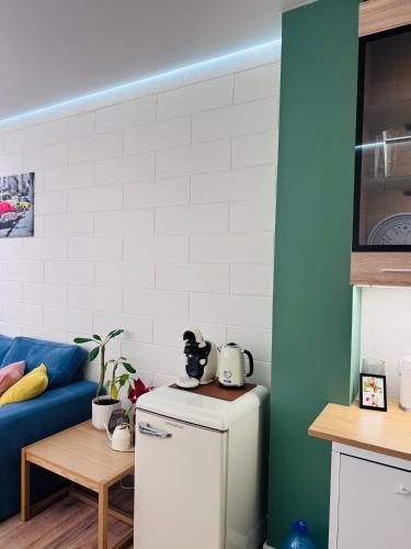 a kitchen with a refrigerator and a blue couch at Апартаменти Dream Space in Khmelʼnytsʼkyy