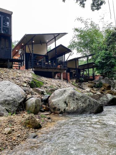 a river with rocks in front of a building at Casa Damai Janda Baik - RIVERVIEW TINY HOUSE in Bentong