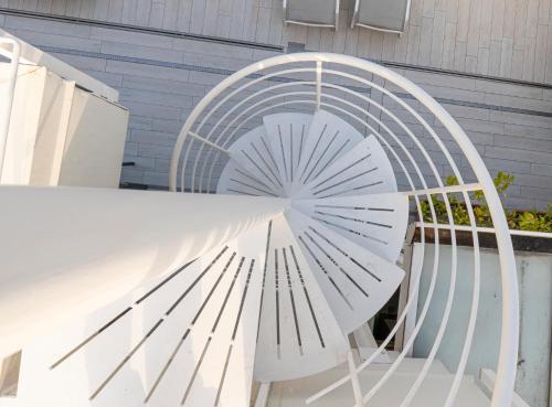 a white spiral stairway with a white metal structure at Room Ravello in SantʼAntonio Abate