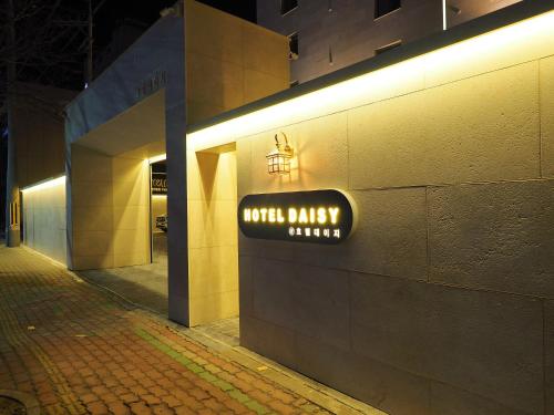 a lighted sign on the side of a building at Daisy hotel in Tongyeong