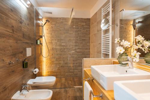 a bathroom with a sink and a toilet at Terra Antica - Resort, Winery & SPA in Montepulciano