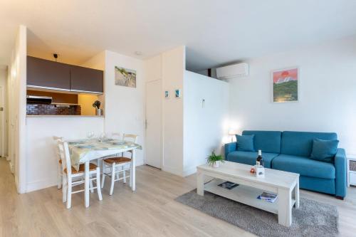 un salon avec un canapé bleu et une table dans l'établissement Chez Édouard 257 - Superbe logement en bord de mer avec parking, à La Grande Motte