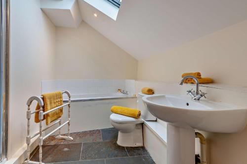 a white bathroom with a sink and a toilet at Castle Forge 4-Bedroom Historic Purbeck Forge in Kingston, Corfe Castle, Sleeps 7 in Kingston