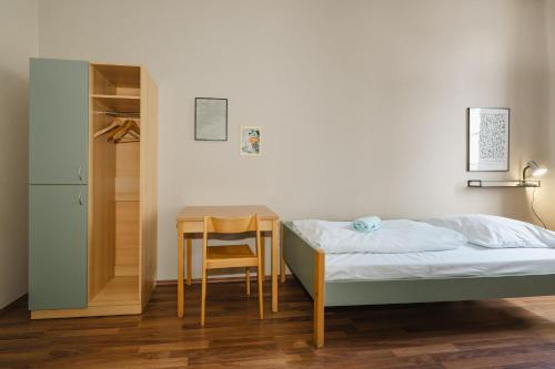 a small bedroom with a bed and a table at Wombat's City Hostel Leipzig in Leipzig