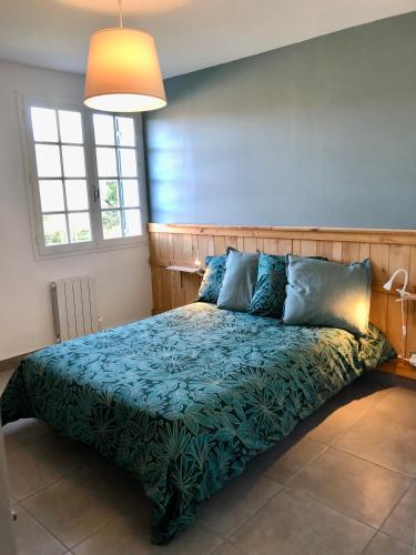 - une chambre avec un lit doté de draps bleus et d'une lampe dans l'établissement Location vacances dans le Périgord vert, à Saint-Front-la-Rivière