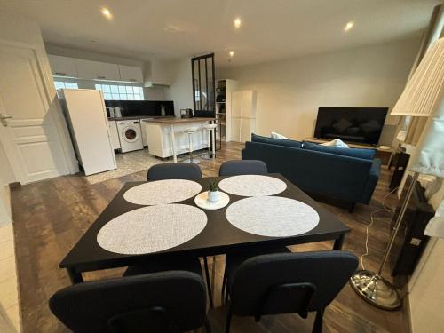 a kitchen and living room with a table and chairs at Charmant T3 lumineux & cosy in Pomponne
