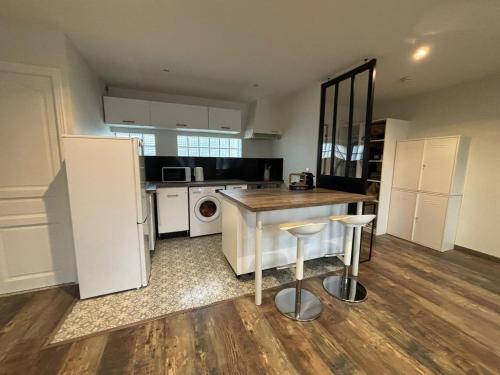 a kitchen with white appliances and a table and stool at Charmant T3 lumineux & cosy in Pomponne