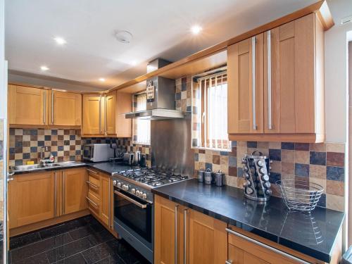 a kitchen with wooden cabinets and a stove top oven at 2 bedroom exclusive house in Sheffield in Sheffield