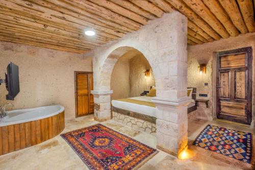 a bedroom with a tub and a bed in a room at Angel View Suites in Goreme