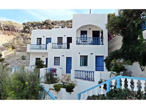 an image of a white building with blue doors at Hotel Glaros Karpathos in Diafani