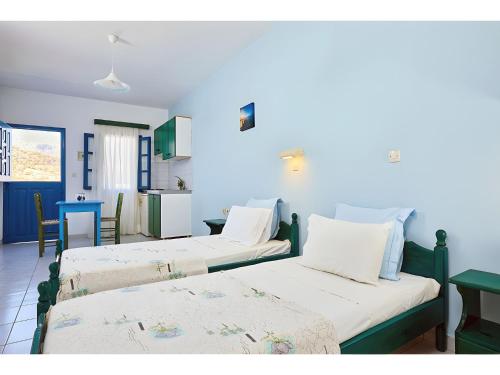 a group of three beds in a room at Hotel Glaros Karpathos in Diafani