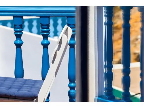 a pair of white chairs sitting on a porch at Hotel Glaros Karpathos in Diafani