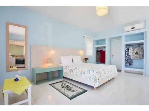 a bedroom with a bed and a table and a mirror at Hotel Glaros Karpathos in Diafani
