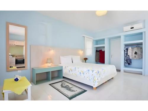 a bedroom with a bed and a table and a mirror at Hotel Glaros Karpathos in Diafani
