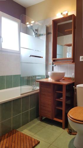 une salle de bain avec un lavabo, des toilettes et une baignoire dans l'établissement Le Brigantin, villa mitoyenne de 68m2 avec terrasse, jardinet et petit garage, à Capbreton