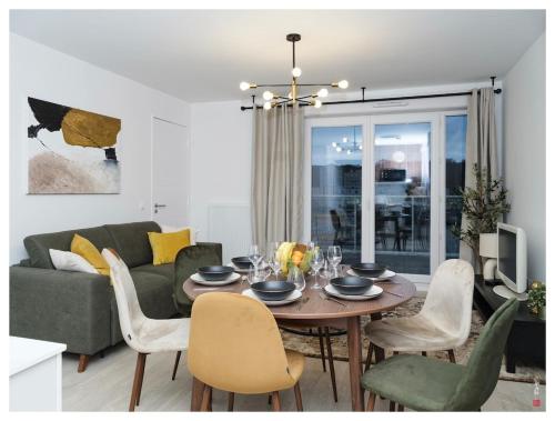 un salon avec une table et un canapé dans l'établissement Chic appart 3 pièces avec Parking et Terrasse à 35min de Paris, à Romainville