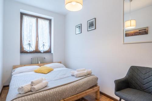 a bedroom with a bed and a chair at Valley Hideaway with private garden near Como lake in Taceno