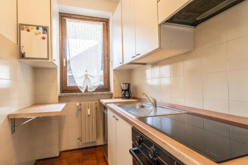 a small kitchen with a sink and a window at Valley Hideaway with private garden near Como lake in Taceno