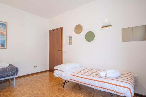 a white bedroom with a bed and a door at Valley Hideaway with private garden near Como lake in Taceno