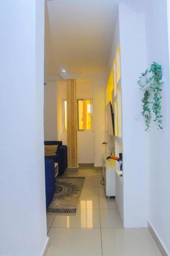 a hallway of a living room with a blue couch at Casa de Luna home in Douala