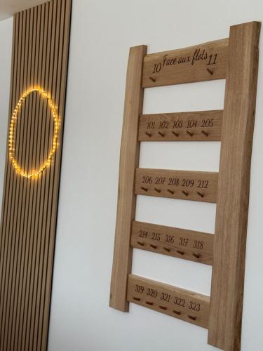 a wooden shelf with a light on the wall at Face aux Flots in La Cotinière