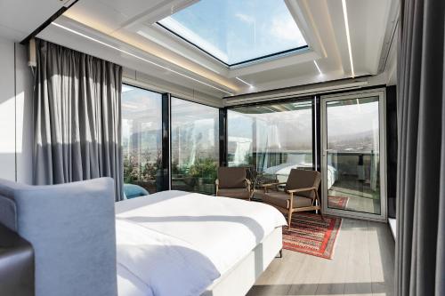 a bedroom with a bed and a large window at Zvezdnaya Eco-Hotel in Almaty
