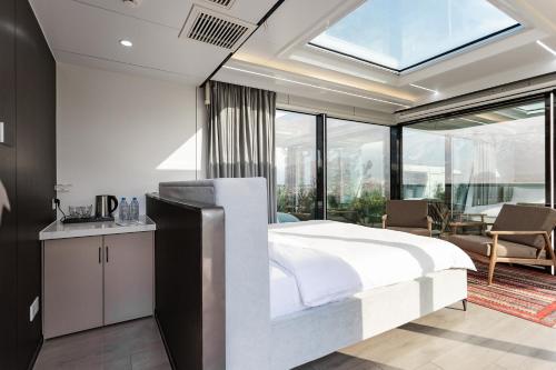 a bedroom with a white bed and a large window at Zvezdnaya Eco-Hotel in Almaty