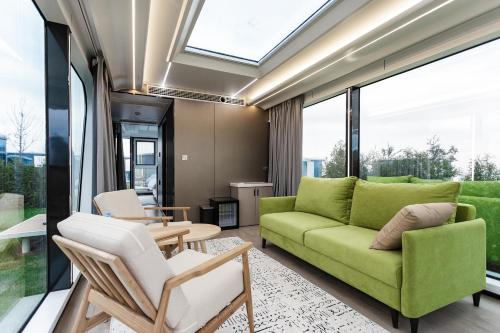 a living room with a green couch and chairs at Zvezdnaya Eco-Hotel in Almaty