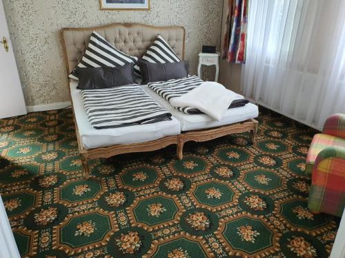a bed with pillows on it in a room at Die Kleine Ferienwohnung in Schneverdingen
