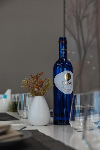 a bottle of wine sitting on a table with glasses at Zvezdnaya Eco-Hotel in Almaty