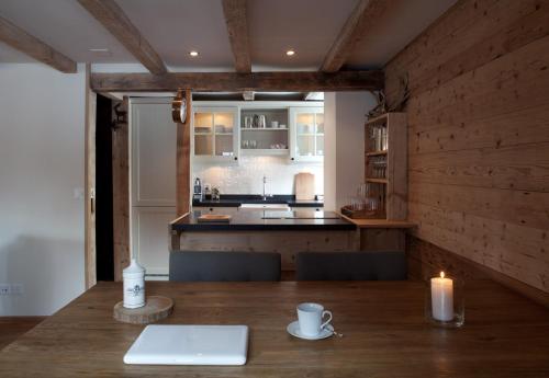 a kitchen with a table with a laptop and a candle at Silverbirch Chalet - Davos in Davos