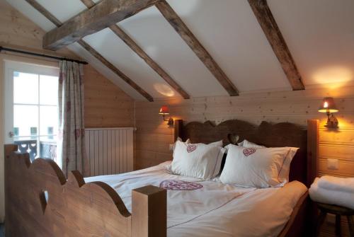 a bedroom with a large bed with white sheets and pillows at Silverbirch Chalet - Davos in Davos