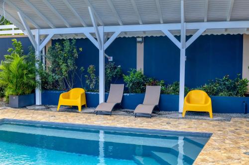 a group of chairs next to a swimming pool at Appartement moderne avec piscine à Pointe-Noire in Pointe-Noire