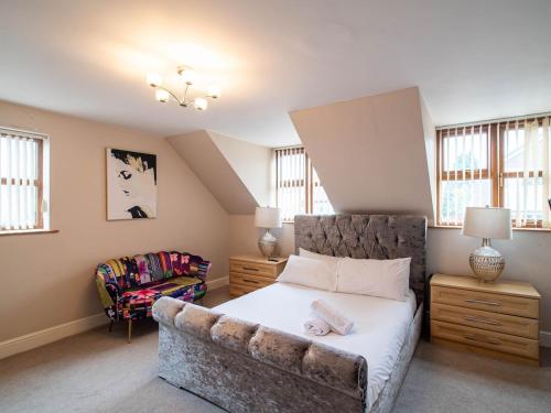 a bedroom with a bed with a couch and a chair at Exclusive 3-Bedroom Villa in Sheffield in Sheffield