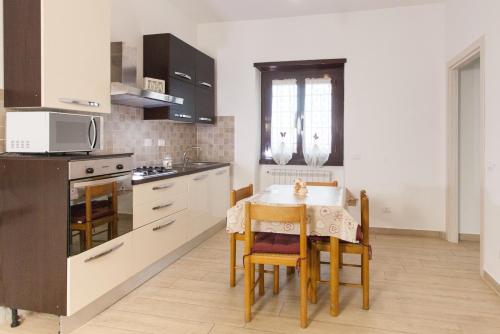 a kitchen with a table with chairs and a microwave at Alloggio turistico a casa di Paoletto in Fiumicino