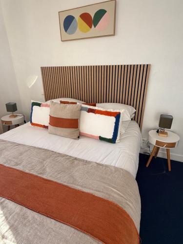 a bedroom with a large bed with colorful pillows at Face aux Flots in La Cotinière