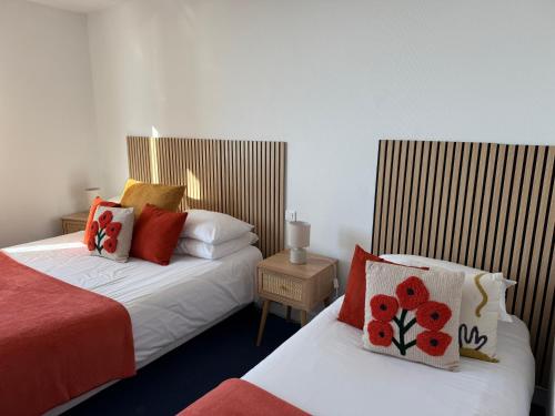a hotel room with two beds with red pillows at Face aux Flots in La Cotinière