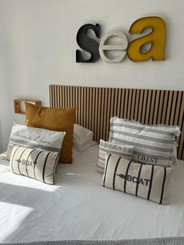 a bed with a pile of blankets and pillows at Face aux Flots in La Cotinière